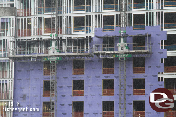 They are using mobile scaffolding to work on the building.  Here they are attaching panels to the frame.