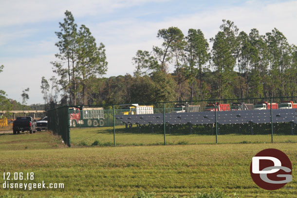 A convoy of dump trucks leaving the construction site as you enter Epcot near the solar farm.