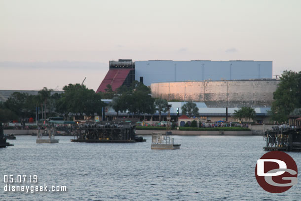 Looking across the World Showcase Lagoon, the Guardians show building towers over Test Track's building.