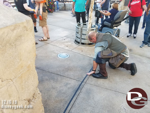 Putting down more tape to try and keep guests out of the PhotoPass area.