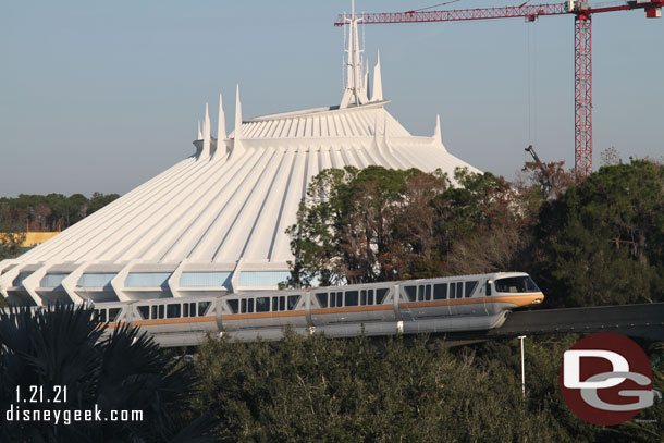 A Monorail passing by Space Mountain.