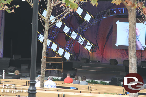 The cast member leading the session sits at desk.