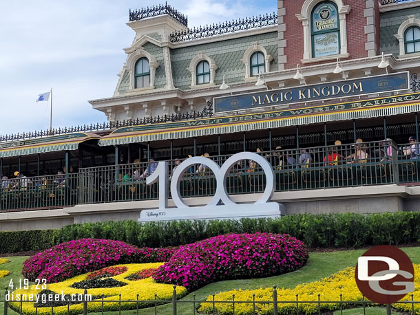 A Disney100 sign above the floral Mickey