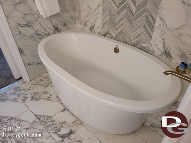A tub is in another room with a sink.